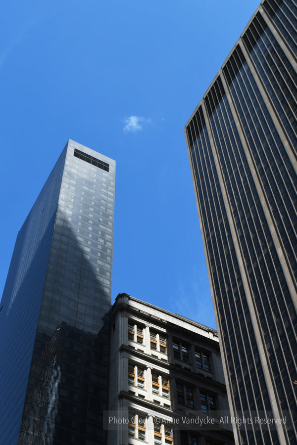 Tall buildings against a clear blue sky. Cityscape View photography by Anne Vandycke.