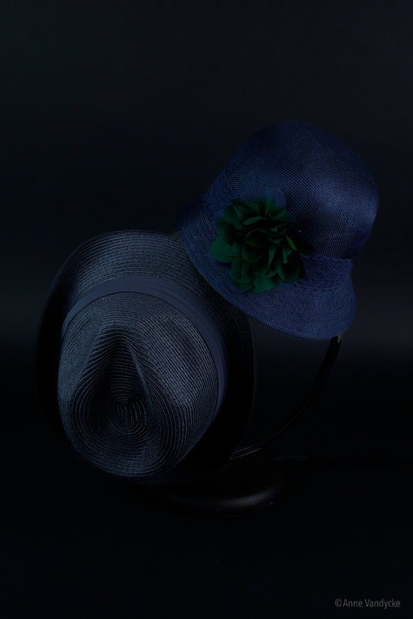 Dark blue hat and black hat on a black background
