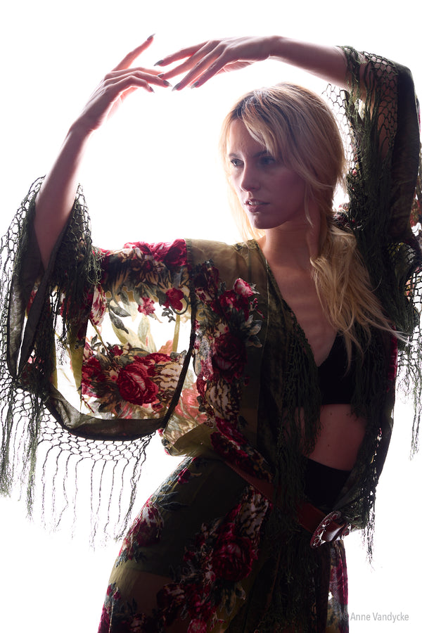 Woman in a floral outfit, posing against a white background. Posed studio photography by NY photographer, Anne Vandycke.