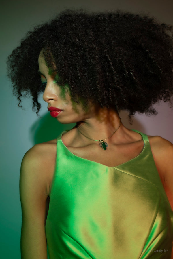 Model wearing a green dress with a plain background. Photo styled and shot by NYC photographer, Anne Vandycke.