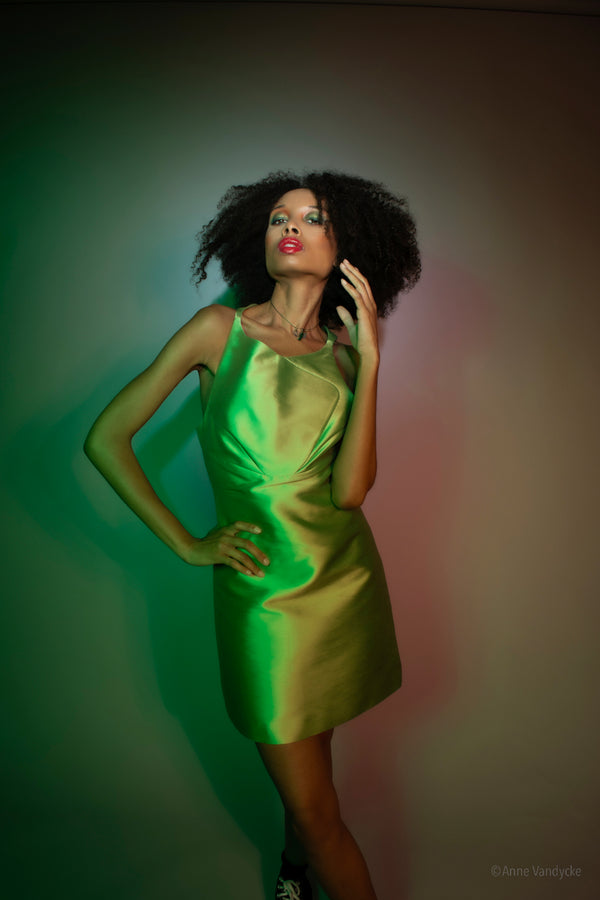 Woman in a green dress posing against a gradient background. Photo by Anne Vandycke, NY photographer.