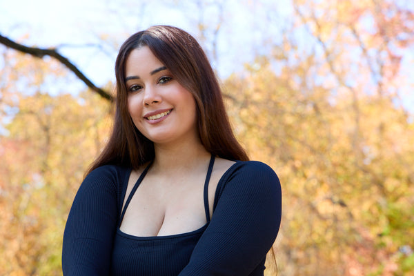 Woman standing outdoors with trees in the background. Outdoor headshot photoshoot by new york photographer.