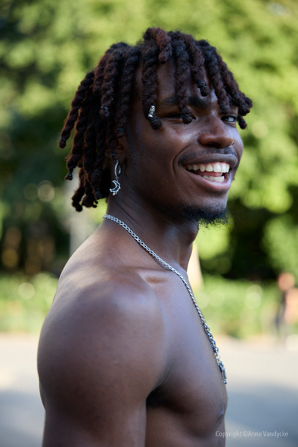 Man smiling outdoors in New York. Photo by Anne Vandycke, New York City Photographer.