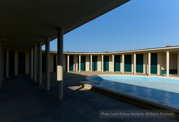 Modern architectural structure with a pool under a clear blue sky. Architecture photography by NYC photographer, Anne Vandycke.