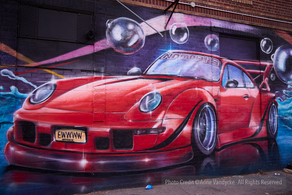 Red sports car mural on a wall with abstract elements. Photography by Anne Vandycke.