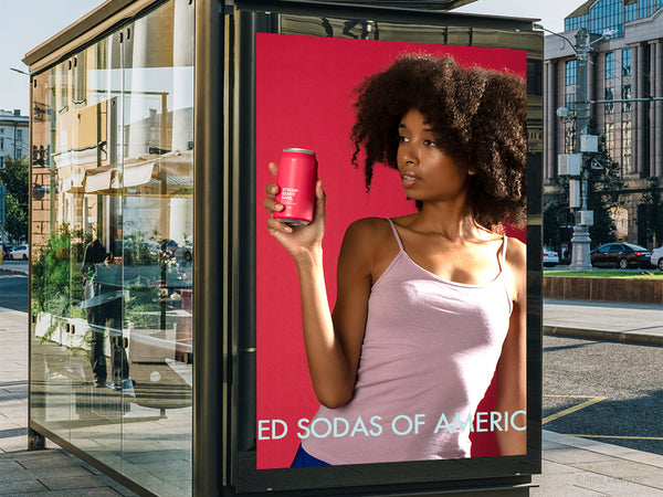 Advertisement on a bus stop featuring a woman holding a pink can against a matching pink background. Photo ad by Anne Vandycke.