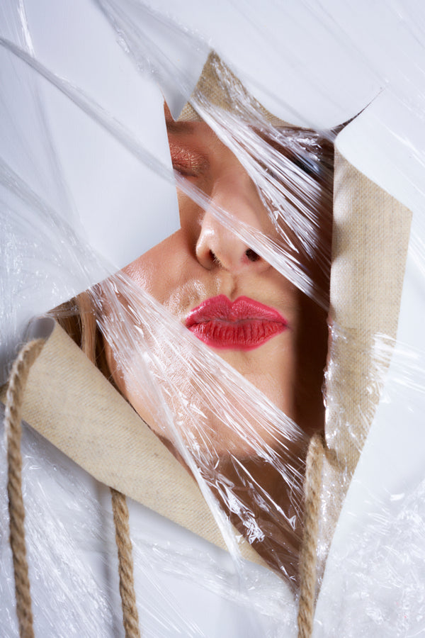 Person with red lipstick peering through art piece "Resilience 3, the Art of transformation."